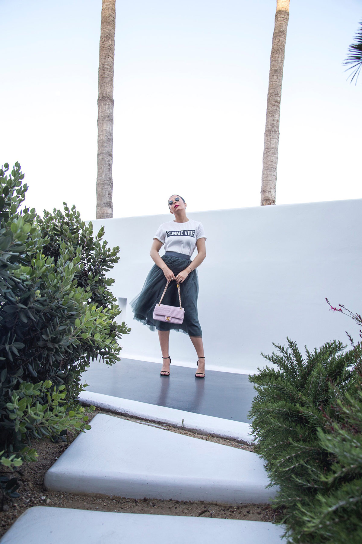 Stella Asteria wearing tulle skirt with logo top, Stuart Weitzman sandals & pink Chanel bag 