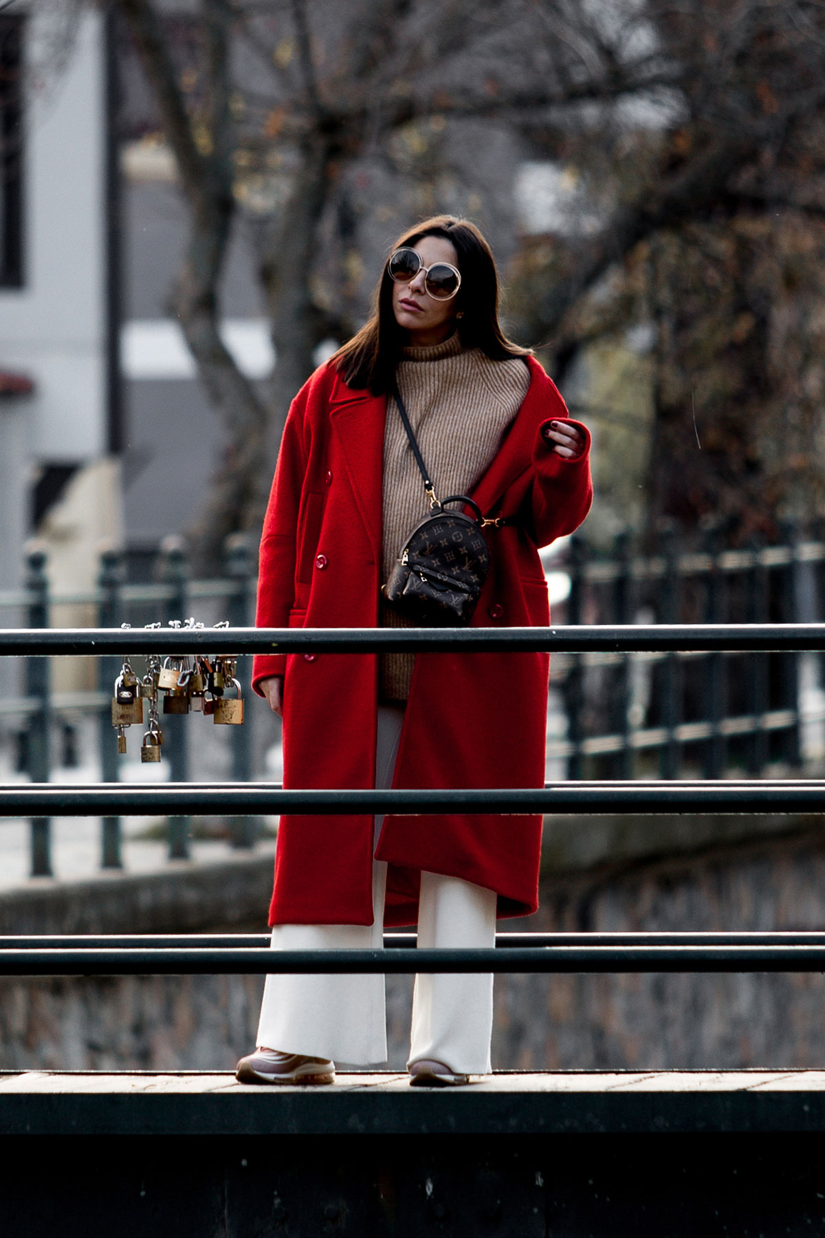 How To Wear A Red Coat - Stella Asteria wearing red coat with beige neutrals, pink Nike millennium sneakers, Louis Vuitton Palm Springs backpack and Chloe sunglasses