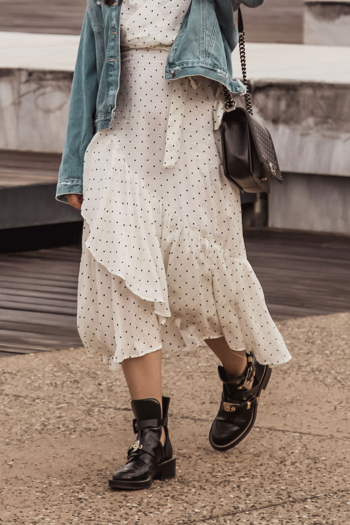 Stella Asteria wearing white polka dot dress with edgy black boots, denim jacket & Chanel boy bag - Spring/Summer 2018 fashion style inspiration