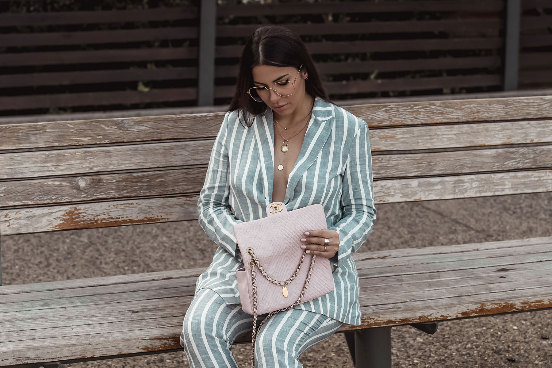 Stella Asteria wearing striped suit and pink Chanel chevron bag